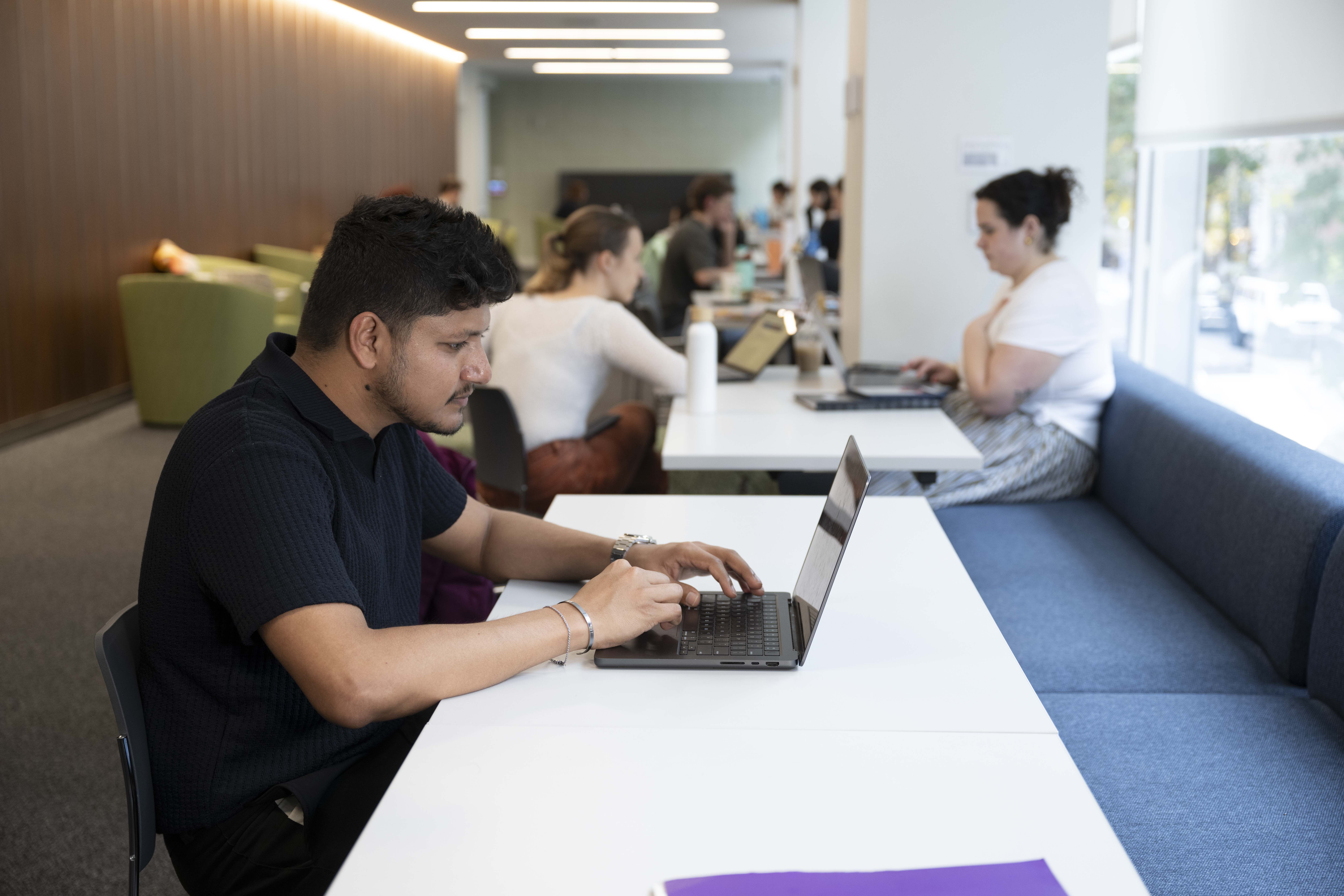 Student sitting at a table with his laptop